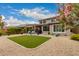Beautiful backyard with green grass, desert landscaping, covered patio, and elegant exterior of home at 28931 N 64Th Dr, Phoenix, AZ 85083