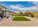 Manicured backyard with artificial turf, desert landscaping, a grill, and a bench at 28931 N 64Th Dr, Phoenix, AZ 85083