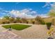 Beautiful backyard featuring an artificial turf area and rock landscaping under a blue sky at 28931 N 64Th Dr, Phoenix, AZ 85083