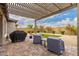 Backyard with artificial turf, a covered patio, rock landscaping, and trees at 28931 N 64Th Dr, Phoenix, AZ 85083