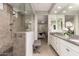 Modern bathroom featuring a glass enclosed shower, double vanity, and a bench at 28931 N 64Th Dr, Phoenix, AZ 85083