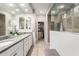 Modern bathroom with double vanity, glass-enclosed shower, and walk-in closet for a spa-like experience at 28931 N 64Th Dr, Phoenix, AZ 85083