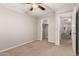 A cozy bedroom featuring neutral walls, carpet, and a ceiling fan, complemented by a spacious closet at 28931 N 64Th Dr, Phoenix, AZ 85083