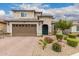 Beautiful two-story home featuring a well-manicured front yard with vibrant desert landscaping and a charming blue front door at 28931 N 64Th Dr, Phoenix, AZ 85083