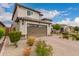 A two-story home with a two car garage and a well-maintained front yard with desert landscaping at 28931 N 64Th Dr, Phoenix, AZ 85083
