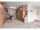 Organized garage featuring plenty of wooden cabinets for storage and epoxy flooring at 28931 N 64Th Dr, Phoenix, AZ 85083