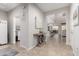 Spacious hallway showcasing tile flooring, elegant decor, and open access to the kitchen and living areas at 28931 N 64Th Dr, Phoenix, AZ 85083