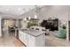 Spacious open-concept kitchen featuring an island with seating, modern appliances, and flows into dining and living areas at 28931 N 64Th Dr, Phoenix, AZ 85083