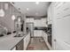 Spacious kitchen with white cabinets, stainless appliances, an island, and a staircase leading to the second floor at 28931 N 64Th Dr, Phoenix, AZ 85083