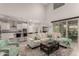 Bright living room with high ceilings, an open-concept kitchen, and comfortable sectional seating at 28931 N 64Th Dr, Phoenix, AZ 85083