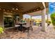 Charming outdoor patio with a ceiling fan, dining table set, and pergola with string lights at 28931 N 64Th Dr, Phoenix, AZ 85083
