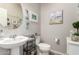 Charming powder room with pedestal sink, coastal decor, and tasteful finishes creating a welcoming space at 28931 N 64Th Dr, Phoenix, AZ 85083