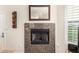 Close up of a living room fireplace with marble tile surround and a wooden framed mirror above at 2929 W Yorkshire Dr # 1066, Phoenix, AZ 85027
