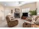 A bright living room showcasing a fireplace, a ceiling fan, and tan upholstered furniture at 2929 W Yorkshire Dr # 1066, Phoenix, AZ 85027