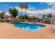 Community swimming pool featuring a built-in spa, rock waterfall feature, covered seating, and pristine blue water at 2929 W Yorkshire Dr # 1066, Phoenix, AZ 85027