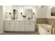 Double sink bathroom vanity featuring white cabinets, stylish mirrors, sconces and a soaking tub at 3047 S Chatsworth --, Mesa, AZ 85212