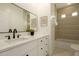 Bright bathroom with white vanity, black hardware, a bathtub with tile surround, and stylish mirror at 3047 S Chatsworth --, Mesa, AZ 85212