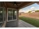 Covered patio with ceiling fan provides view of backyard with grass and desert landscaping at 3047 S Chatsworth --, Mesa, AZ 85212
