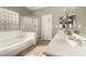 Bathroom featuring a separate tub and glass-enclosed shower, along with dual sinks and plenty of counter space at 3387 E Bluejay Dr, Chandler, AZ 85286