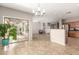 Open living space with tile floors, direct access to outdoor patio, view of the kitchen, and neutral color palette at 3387 E Bluejay Dr, Chandler, AZ 85286