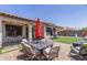 Charming backyard with a patio set and vibrant green artificial turf for entertainment at 36197 W Cartegna Ln, Maricopa, AZ 85138