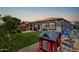 Expansive backyard with a playhouse, swing set, and a charming patio, creating an inviting space for Gathering enjoyment at 36197 W Cartegna Ln, Maricopa, AZ 85138