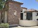 The exterior showcases a unique architectural style with stucco walls, stone accents, and charming outdoor decor at 36197 W Cartegna Ln, Maricopa, AZ 85138