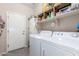 Functional laundry room with modern washer and dryer and ample storage space at 36197 W Cartegna Ln, Maricopa, AZ 85138