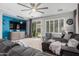 Comfortable living room featuring a modern ceiling fan, gray walls, and access to the backyard through sliding glass doors at 36197 W Cartegna Ln, Maricopa, AZ 85138