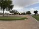 Community park showcasing a putting green and gathering spaces amidst a backdrop of trees, ideal for outdoor activities at 36197 W Cartegna Ln, Maricopa, AZ 85138