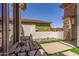 Cozy outdoor patio features a charming table setting and scenic views of the landscaped backyard and surrounding neighborhood at 36197 W Cartegna Ln, Maricopa, AZ 85138