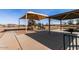 A shaded playground featuring climbing structures, slides, and a covered picnic area for community enjoyment at 36197 W Cartegna Ln, Maricopa, AZ 85138
