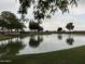 Scenic view of a tranquil pond, reflecting the surrounding trees and sky, providing a serene and picturesque setting at 36197 W Cartegna Ln, Maricopa, AZ 85138