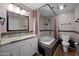 Bathroom boasts a shower and tub combo, granite vanity, and neutral tile, for a relaxing retreat at 4115 W Danbury Dr, Glendale, AZ 85308