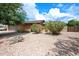 Home with desert landscape and mature tree in the front at 4115 W Danbury Dr, Glendale, AZ 85308