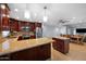 Open kitchen with granite counters, stainless appliances and dark cabinets flows into dining and living areas at 4115 W Danbury Dr, Glendale, AZ 85308