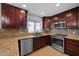Well-appointed kitchen with granite countertops, stainless steel appliances, and dark wood cabinets at 4115 W Danbury Dr, Glendale, AZ 85308
