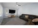 A spacious living room with plush carpet, ceiling fan, and a comfortable leather sectional sofa, great for entertainment at 4115 W Danbury Dr, Glendale, AZ 85308