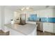 Modern kitchen featuring stainless steel appliances, white cabinetry, a grey countertop island, and blue subway tile backsplash at 5047 N 83Rd St, Scottsdale, AZ 85250