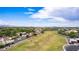 Expansive aerial view of a residential neighborhood with a large grassy field and mountain views in the distance at 5052 W Boston S Way, Chandler, AZ 85226