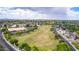 High aerial perspective capturing a vast residential area, a grassy field, and a clear view of the horizon at 5052 W Boston S Way, Chandler, AZ 85226