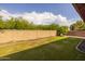 Spacious backyard featuring lush green grass and privacy wall, ideal for outdoor activities and peaceful enjoyment at 517 S 165Th Dr, Goodyear, AZ 85338