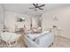 Cozy living room with neutral tones, ceiling fan, tile flooring, and comfortable wicker furniture at 517 S 165Th Dr, Goodyear, AZ 85338