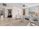 Bright living room with neutral colors, wicker furniture, tile floors, and abundant natural light at 517 S 165Th Dr, Goodyear, AZ 85338