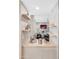 Stylish wet bar featuring open shelving and elegant glassware storage leading to the living room at 6220 E Paradise Ln, Scottsdale, AZ 85254