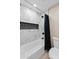 Tiled bathroom with a tub and shower combo, featuring a dark shower curtain at 6220 E Paradise Ln, Scottsdale, AZ 85254