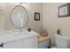 Cozy half-bathroom with stylish round mirror, wood accents, and classic toilet at 6220 E Paradise Ln, Scottsdale, AZ 85254