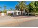 Charming single-story house showcasing desert landscaping, a lush green tree, and a spacious circular driveway at 6220 E Paradise Ln, Scottsdale, AZ 85254