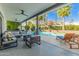 Covered patio boasts ample seating, a cozy fire pit, and views of the sparkling pool and lush landscaping at 6220 E Paradise Ln, Scottsdale, AZ 85254