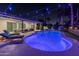 Inviting backyard with a sparkling pool, lounge chairs, and stylish patio furniture, perfect for relaxation under string lights at 6220 E Paradise Ln, Scottsdale, AZ 85254